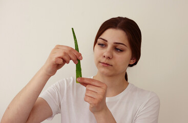 Young woman holds leaf of aloe vera