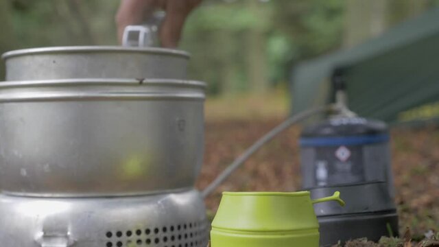 Preparing two hot beverages in the forest while camping, Static Shot