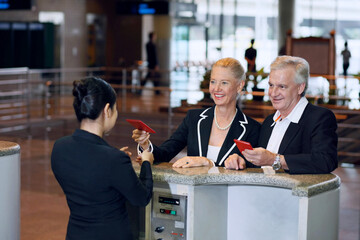 Businessman and businesswoman at the airport check-in counter with their passports
