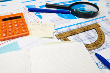 business office desk closeup - financial reports, analysis and accounting, set of documents, tables and graphs, various items for bookkeeping, calculator