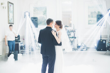 Naklejka premium First wedding dance of newlywed couple in restaurant