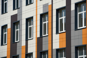 Fototapeta premium facade of a modern building on a bright Sunny day, siding and Windows, beautiful exterior of the new building