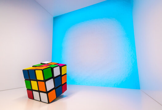 Shuffled Rubik's Cube inside a cube with light blue background