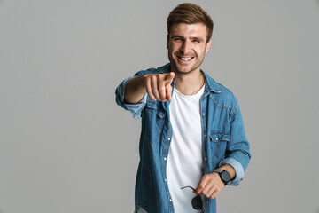 Portrait of cheerful man laughing and pointing finger at camera