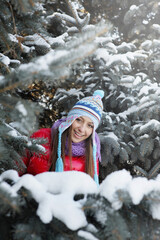 Fototapeta na wymiar Woman in warm clothing standing among the snow covered trees