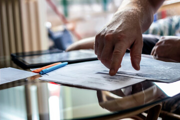 Image of male hand pointing at business document.Businessman discussing the charts and graphs showing the results of their successful teamwork.Close-up of male hands pointing at document.