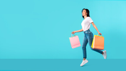 Overjoyed woman running with shopping bags at studio
