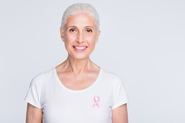 Close up photo of charming lady looking at camera holding pink symbol on her stylish t-shirt...