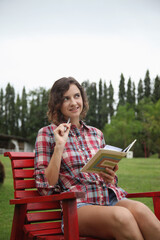 Woman sitting on a chair, writing diary