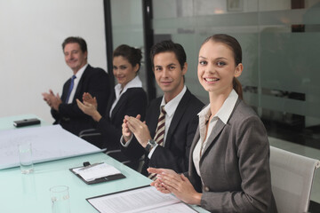 Business people clapping hands in conference room