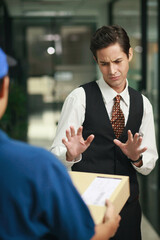 Businessman rejecting package from delivery person