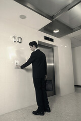 Fototapeta premium Businessman pushing elevator button