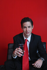 Businessman with a glass of water sitting on sofa