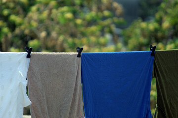 Colorful cloths are drying under sunlight and blur nature background.