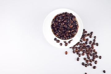 Coffee beans in coffee cup isolated on old wooden background,