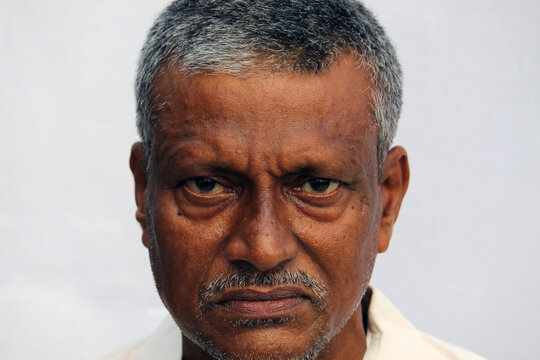  Angry, sad or worried looking senior Indian man face portrait on white background.