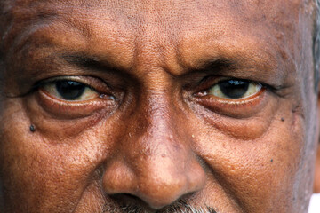 Senior Indian man's eyes and wrinkles on skin close view.