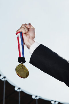 Hand Holding Gold Medal