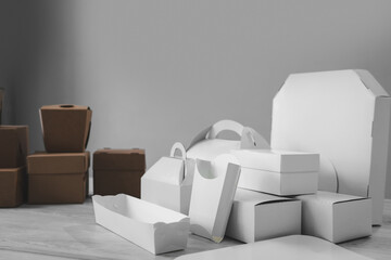 Different types of white and brown cardboard packaging. For fast food, folding, large and small. The concept of production and design of paper products. Place for text. Selective focus.