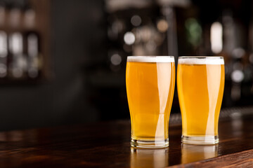 Event beer in pub. Two glasses of ale on bar in interior