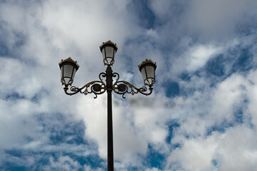 Fototapeta na wymiar Contrapicado de una farola clásica con el cielo nublado de fondo