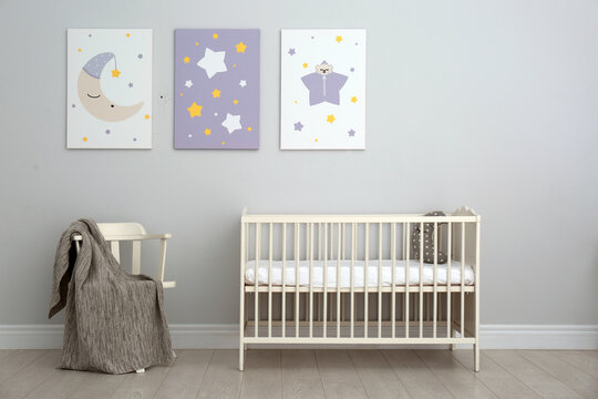 Baby room interior with crib and cute posters on wall