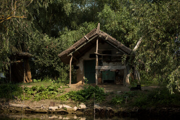 Old wooden house on a channel in Danube Delta,  Romania,  in a sunny summer day