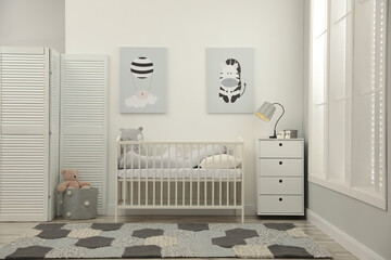 Stylish baby room interior with crib and chest of drawers