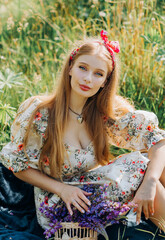Naklejka premium Lovely cute woman in lupine field, sunny day, freedom concept