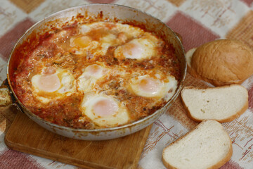 shakshuka - jewish national dish with fried eggs species, tomato, pepper garlic