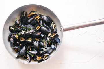 Steamed mussels cooked on a big pot  fresh fish mussels daily taken from sea cooked on a white...