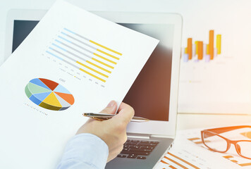 Finance and business concept. Hand pointing at statistics chart. calculator on financial graphs on desk.  Accounting budgeting loans or market analysis. Business growth. Female small business