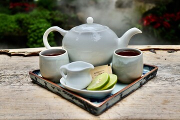 Tea composition with a lemon leaf on wooden palette