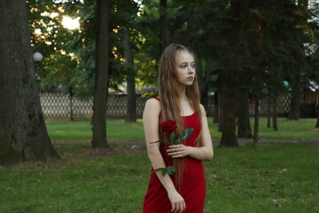slender blonde girl in a short red dress with a red rose