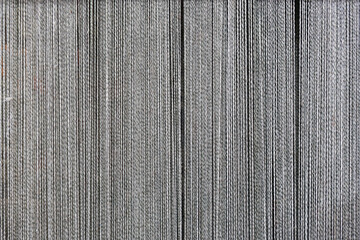 Background with vertical threads. Lots of white threads on a dark background.