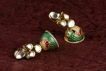 Beautiful Golden pair of earrings Diamonds gemstones on textued background. Luxury female jewelry, Indian traditional jewellery, kundan earring,Bridal Gold earrings wedding jewellery