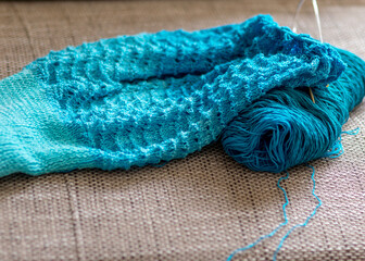 knitted sweater, knitting needles and yarn, close-up view