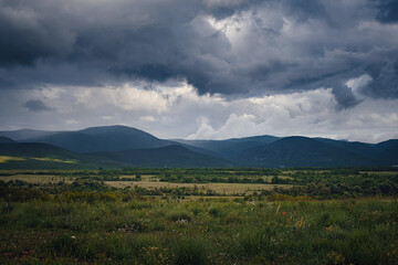 Picturesque green valley among the mountains before a storm.