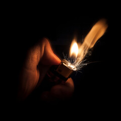 Flame and sparks from a lighter being lit. © inakimt