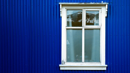 White window on blue facade