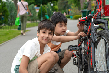 Obraz premium Two young brothers riding their bicycles outside
