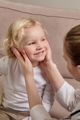 A female doctor in a medical coat examines a child. Family doctor.