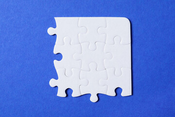 Blank white puzzle pieces on blue background, flat lay