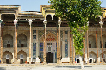 Fototapeta na wymiar Bolo Pool Mosque was built in 1712. The handcrafted decorations of the mosque made of wood are famous. There is a large pool in front of the mosque. Bukhara, Uzbekistan. 