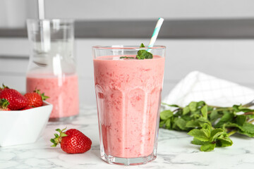 Tasty strawberry smoothie with mint in glass on white marble table