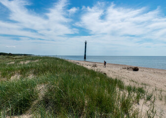 traditional summer landscape with sandy and pebbly promontory, green dune grass, abandoned sloping...