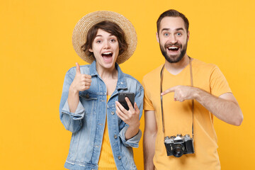Excited young tourists couple friends guy girl isolated on yellow background. Passenger traveling...