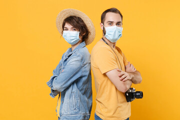 Young tourists couple two friends guy girl in sterile face mask isolated on yellow background....
