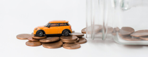 A model car is on coins. Rising costs for gasoline car prices, insurance and taxes.