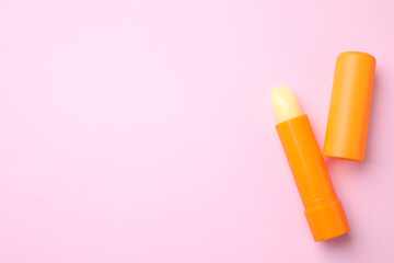 Hygienic lipsticks on pink background, flat lay. Space for text